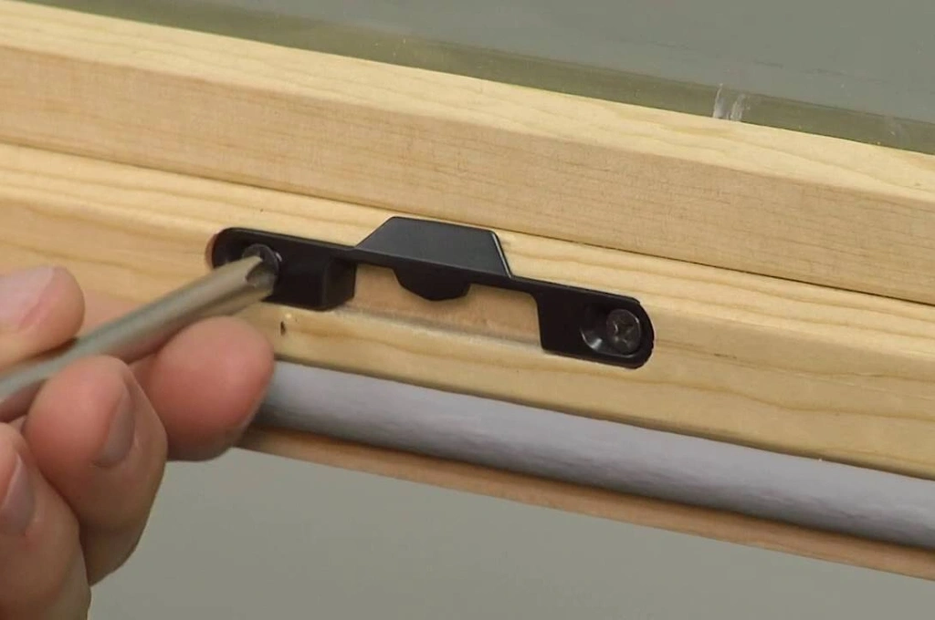 RHS technician inspecting a foggy double-glazed window for condensation repair.